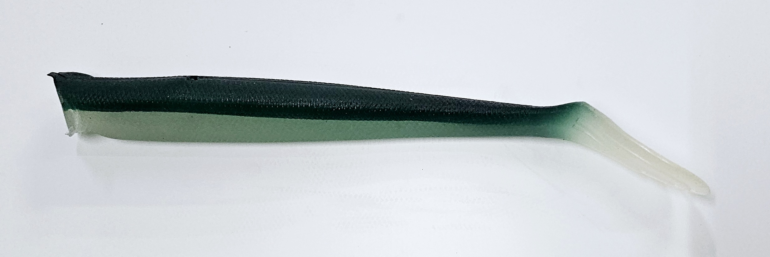 Realistischer Shad-Köder zum Süßwasserangeln, ideal für Barsch und Hecht. Weicher Kunststoffköder in dunkelgrüner und weißer Farbe. – Fishing Adventure GmbH